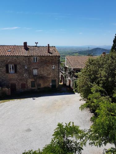 an old building with a parking lot in front of it at Borgo al Cielo - Albergo Diffuso in Suvereto