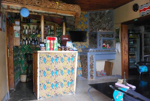 a room with a bar with a counter with bottles of alcohol at Crater Bay Cottages in Kabale