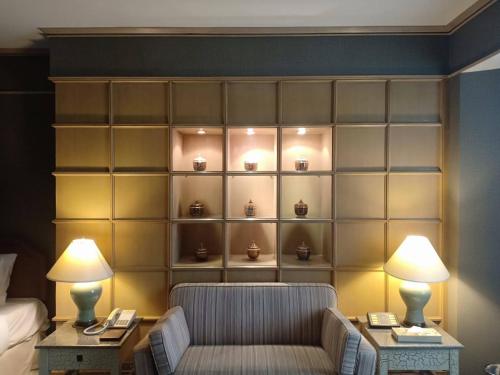 a room with a wall with a couch and two lamps at The Maruay Garden Hotel in Bangkok