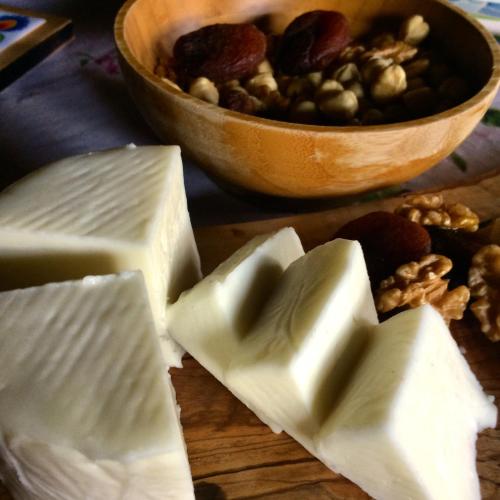 un mucchio di formaggio su un tagliere con una ciotola di noci di Kamarca House Hotel a Ortaca