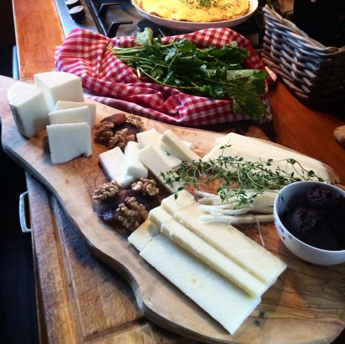 un tagliere con formaggio e verdure su una tavola di Kamarca House Hotel a Ortaca