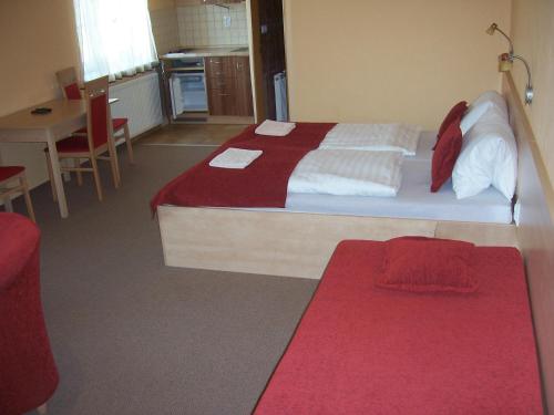 a bedroom with a bed with a red and white blanket at Pension Euro in Mikulov
