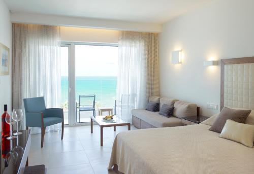 a hotel room with a bed and a living room at Sunrise Pearl Hotel & Spa in Protaras