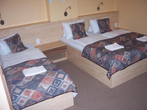 a hotel room with two beds with towels on them at Pension Euro in Mikulov