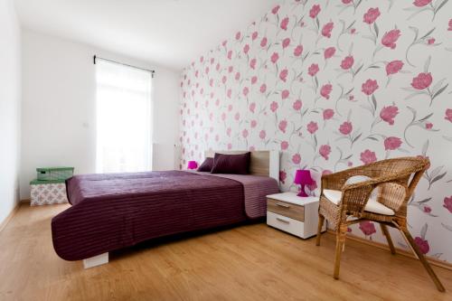 a bedroom with a bed and pink floral wallpaper at Grand Budapest Penthouse in Budapest