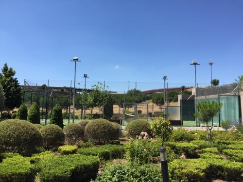 a garden in front of a building with bushes at Lujoso Loft La Moraleja in Madrid
