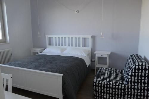 una camera bianca con un letto e una sedia di Vento Barocco - Equitazione e Turismo a Matera