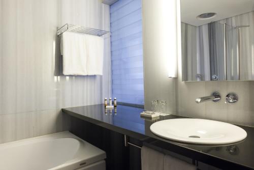 a bathroom with a sink and a toilet and a mirror at Sunrise Pearl Hotel & Spa in Protaras