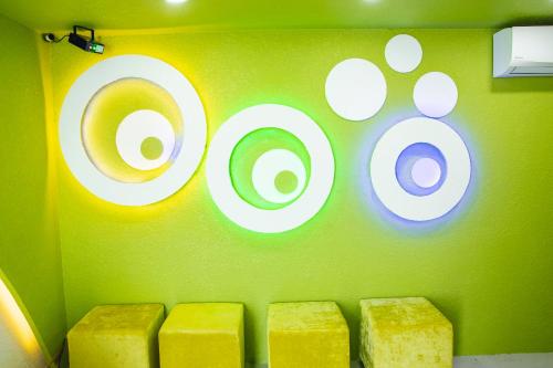 a green wall with white circles and four yellow blocks at Mui Ne Beach Hotel in Mui Ne