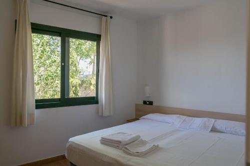 a bedroom with a bed with two towels on it at 2 bedroom apartment in Begur center. Sea views, terrace and pool (Ref:H09) in Begur
