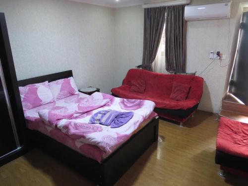 a bedroom with a bed and a couch and a chair at Lana Apartment in Tbilisi City
