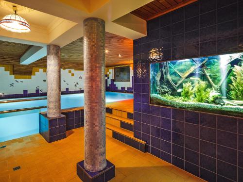 a bathroom with an aquarium on the wall at Czarny Potok Wellness & Spa Zakopane Centrum in Zakopane