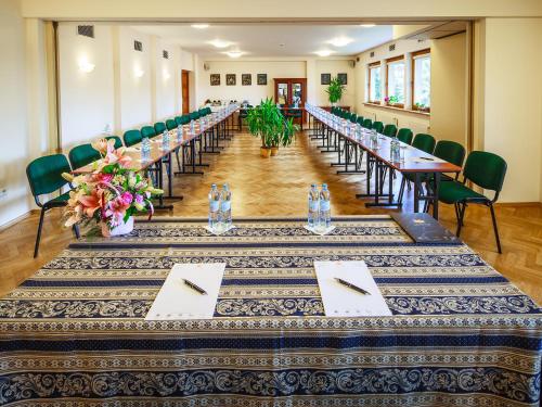 a long row of tables in a room with green chairs at Czarny Potok Wellness & Spa Zakopane Centrum in Zakopane