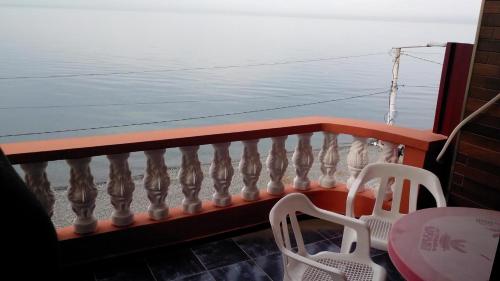 a balcony with a table and chairs and the ocean at Guest House Rusalka in K'obulet'i