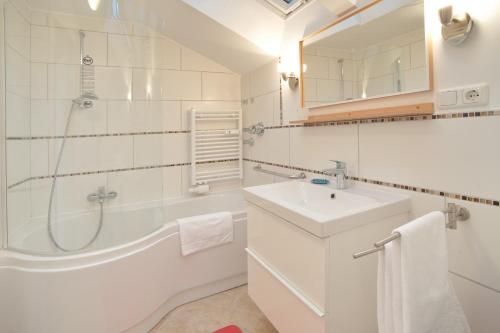 een witte badkamer met douche en wastafel bij Rotspitz in Sonthofen