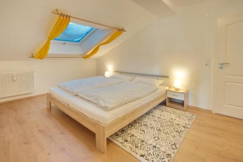 een slaapkamer met een bed met een raam en een tapijt bij Rotspitz in Sonthofen