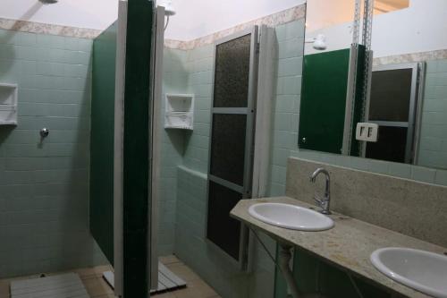 a bathroom with two sinks and a mirror at Hostel 33 Brazil in Guarulhos