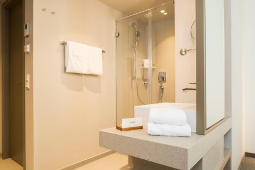 a bathroom with a sink and a shower at Das ACKER Hotel in Neuburg an der Donau