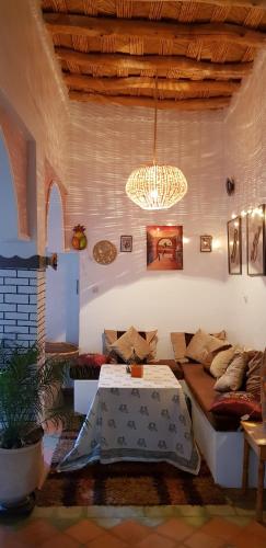 a living room with a couch and a chandelier at Miguirne Chez Ali in Tamellalt
