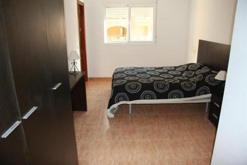 1 dormitorio con cama y ventana. en Alta Entinas, en Almerimar