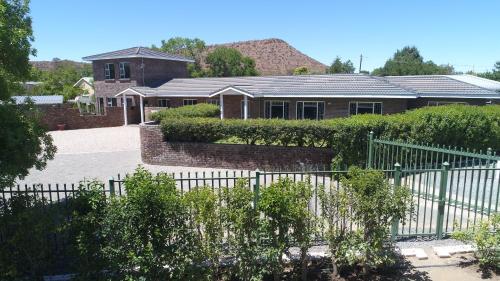 une maison avec une clôture devant elle dans l'établissement Sunset Chalets & SCA, à Colesberg