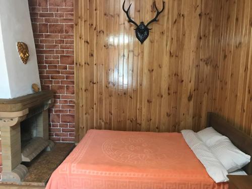 a bed in a room with a wood wall at Holiday Home Rayskiy Ugolochek in Kvitki
