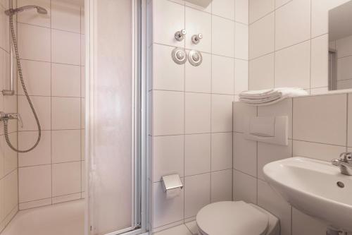 ein Bad mit einer Dusche, einem WC und einem Waschbecken in der Unterkunft StayInn Apartments City Center in Freiburg im Breisgau