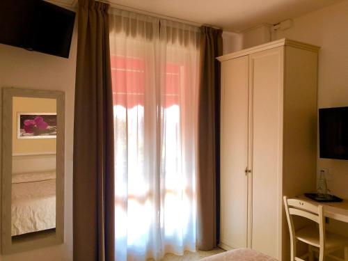 a bedroom with a window with a bed and a dresser at Villa Emma Malcesine in Malcesine