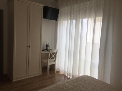 a bedroom with a bed and a chair and a window at Villa Emma Malcesine in Malcesine
