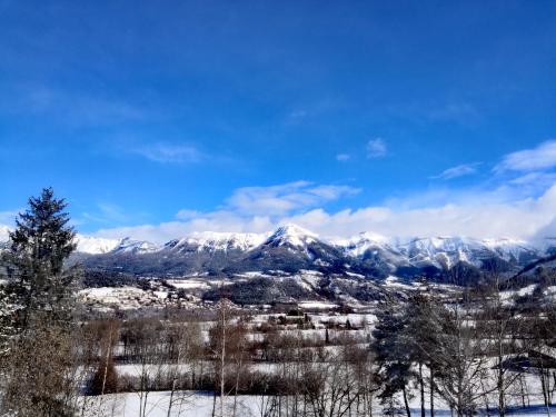 a mountain range with snow covered mountains in the distance at Gîte de Champflorin in Seyne