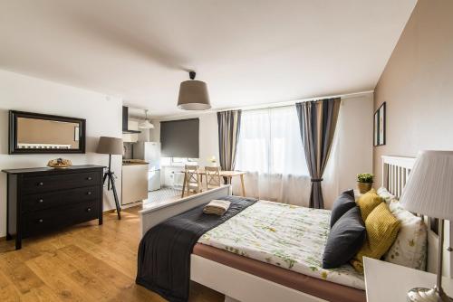 a bedroom with a bed and a desk and a window at Sunshine Apartment in Liepāja