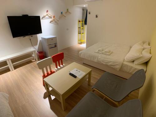 a small room with a bed and a table and chairs at Chill Place in Zhudong
