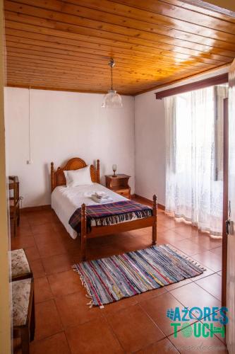 a bedroom with a bed and a large window at Quinta de Sao Carlos in Angra do Heroísmo