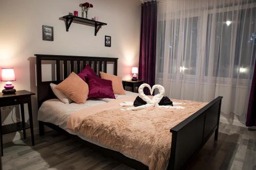 a bedroom with a bed with two towels on it at Liget Apartman in Gyula