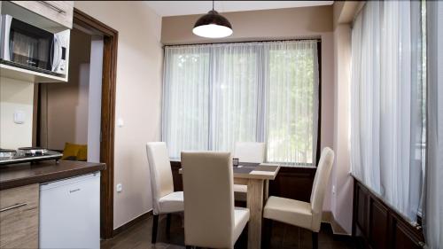 a kitchen and dining room with a table and chairs at Liget Apartman in Gyula