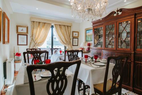 a dining room with a table and chairs and a chandelier at Lourenço's House Deluxe Cascais in Cascais