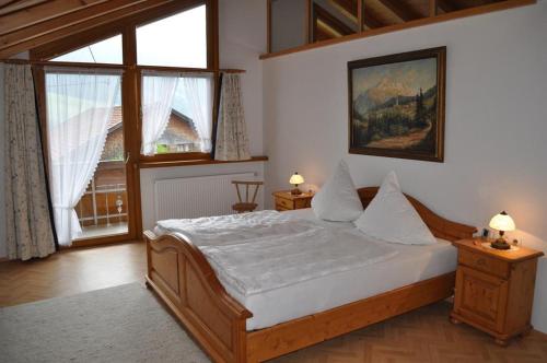 a bedroom with a bed and a large window at Beim Jokelar in Bad Hindelang