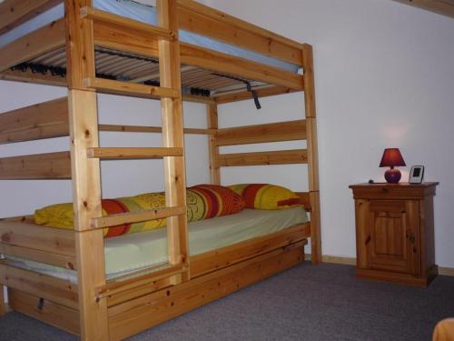 a wooden bunk bed in a room with a night stand at Ferienwohnung Iselerblick in Bad Hindelang