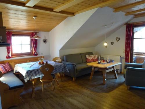a living room with a couch and a table at Ferienhof Beim Kemptar in Bad Hindelang