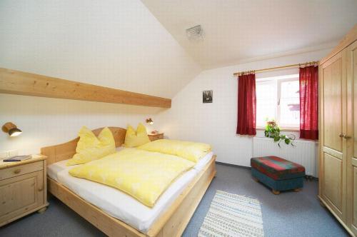 a bedroom with a large bed with yellow sheets at Haus Berktold in Bad Hindelang