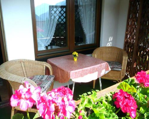 een patio met een tafel, stoelen en bloemen bij Chalet Hirschberg in Bad Hindelang