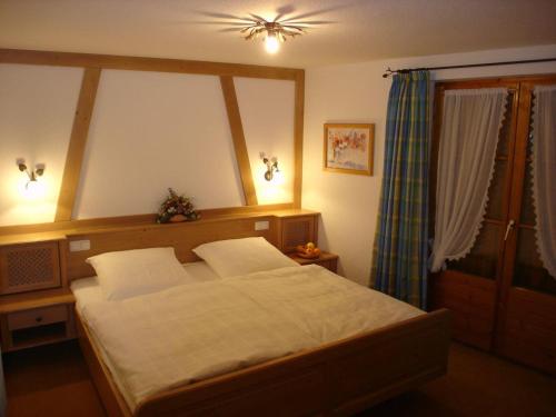 a bedroom with a large bed and a window at Haus Geiger in Bad Hindelang