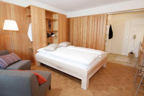 1 dormitorio con cama blanca y sofá en Hochherz - fewo-badhindelang, en Bad Hindelang