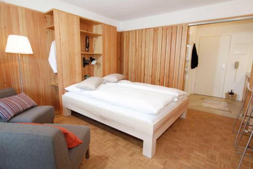 a bedroom with a white bed and a couch at Hochherz - fewo-badhindelang in Bad Hindelang