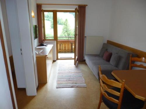 a living room with a blue couch and a table at Haus Marianne in Oberjoch