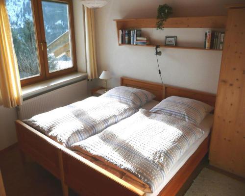 twee bedden in een kamer met een raam bij Chalet Hirschberg in Bad Hindelang
