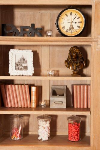 a wooden shelf with a clock and a microwave at Hôtel de Bellevue Paris Gare du Nord in Paris