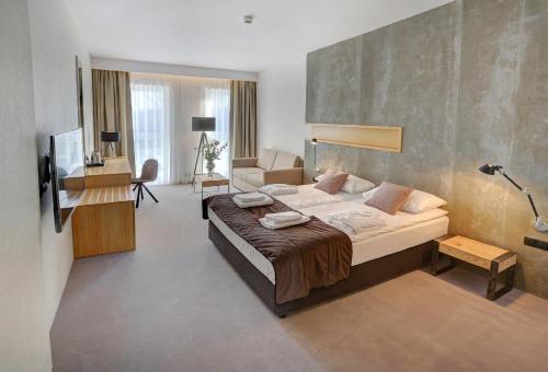 a bedroom with a large bed and a living room at Folwark Łochów in Łochów
