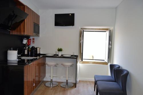 una cucina con bancone, sgabelli e finestra di Modern Cozy Studio - Portas Do Sol a Lisbona