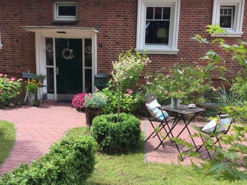 a brick house with a table and chairs in the yard at FeWo Ostsee Ahoi in Timmendorfer Strand